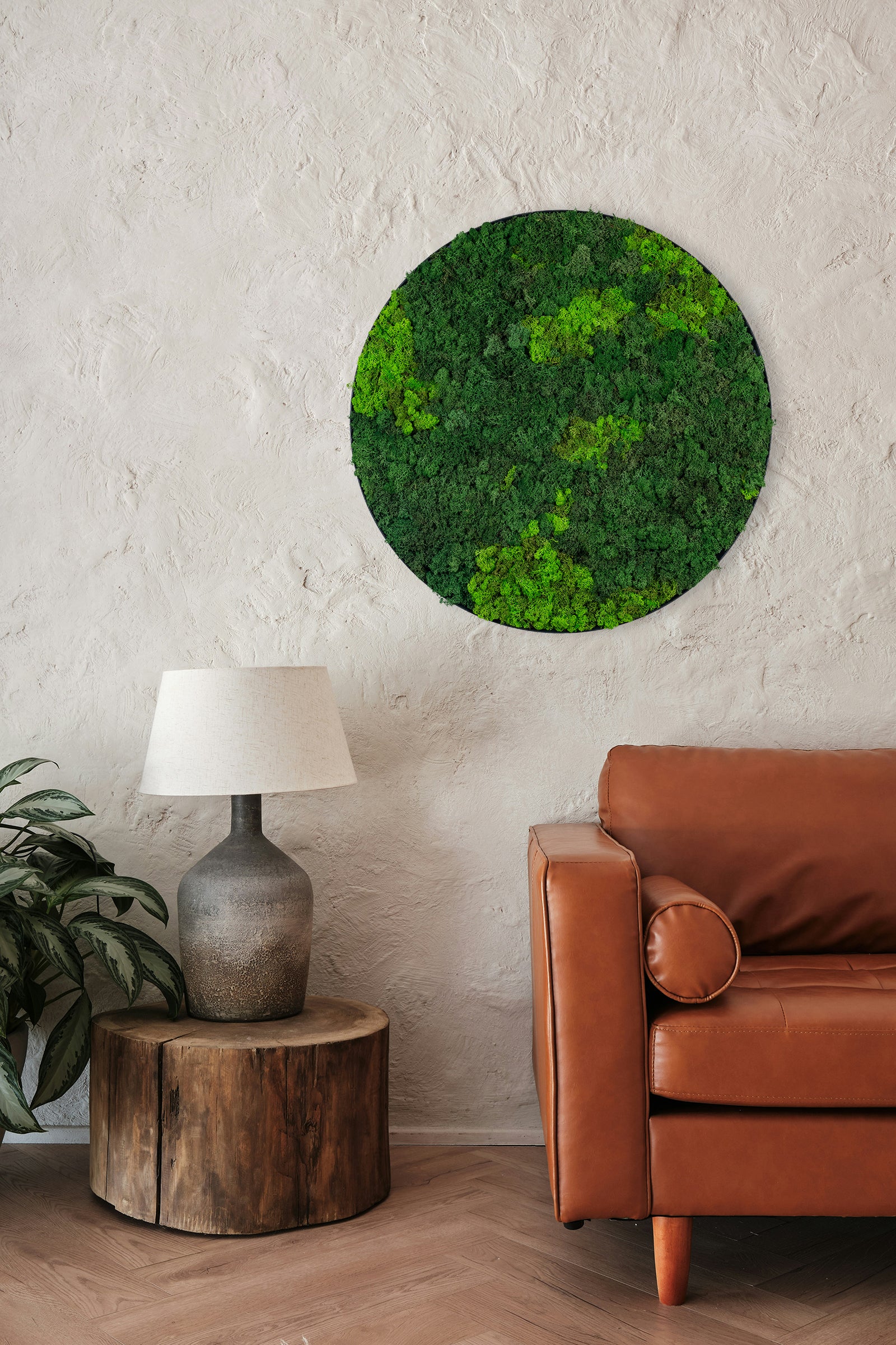 Rundt mosbillede med grønt mos i flere nuancer og sort kant. Moskunst skaber en behagelig akustik og en afslappet atmosfære. 